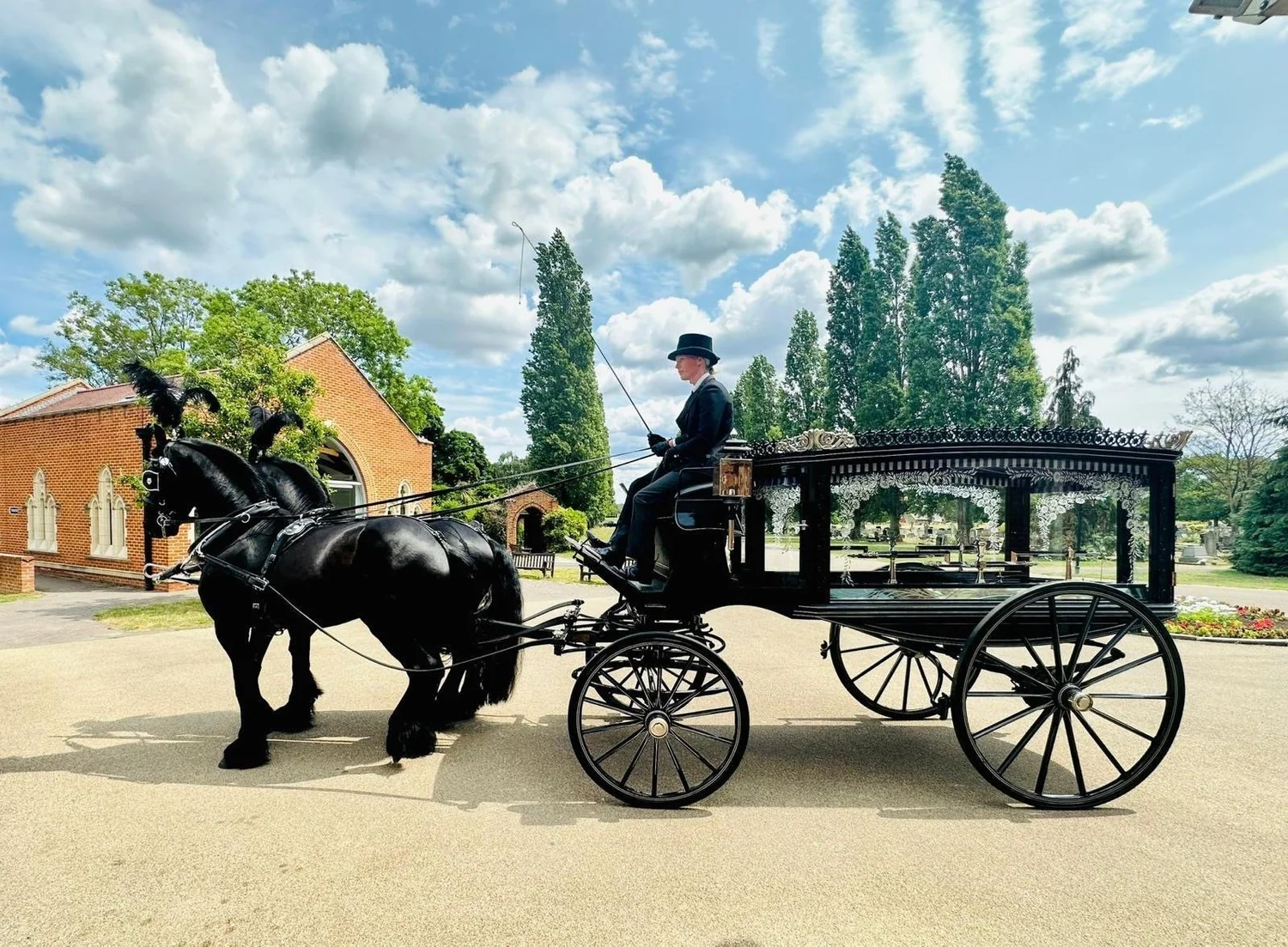 Traditional black horse-drawn carriage hearse setup